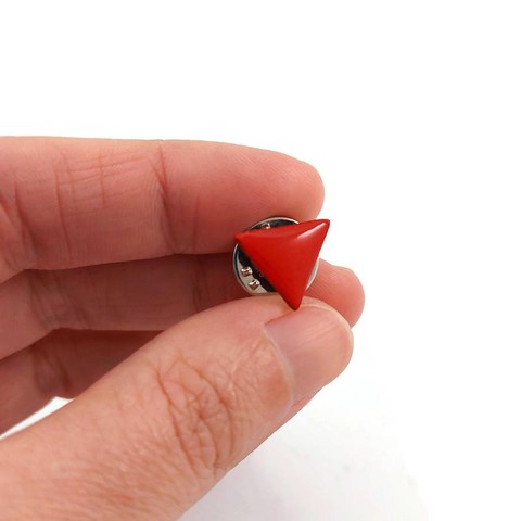 Pin's éco-responsable en forme de petit triangle rouge inversé (symbole de la Lutte Ouvrière et de l'antifascisme.
La perle est réalisée en CD recyclé, découpée et peinte à la main, puis recouverte de résine époxy.